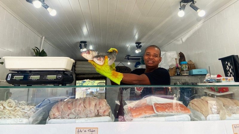 Luiz Alves Santos, conhecido como Lula, é funcionário do box 12 do mercado de peixes, e vê melhora no movimento nesta Semana Santa - Rebeca Freitas