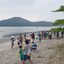 Esta imagem mostra um grupo de crianças e adultos a participar numa ação de limpeza de uma praia em Ubatuba