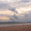 Praia com sol e muitas nuvens.
