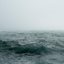 Imagem mostra um mar agitado e tempestuoso, com ondas encrespadas e uma névoa densa cobrindo a linha do horizonte