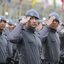 Policiais militares de São Paulo, em formação e usando uniformes cinza e boinas
