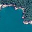 Vista aérea da praia de Palmira, em Ubatuba, cercada por vegetação e formações rochosas