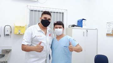 José Antonio dos Santos agradeceu pelo carinho que sempre recebeu nos 18 anos trabalhando em Bertioga Profissional de saúde com o paciente Profissional de saúde com o paciente, ambos de máscara - Arquivo Pessoal