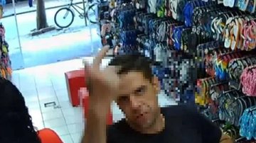 Homem pediu para as pessoas não correrem e saiu tranquilamente andando da loja com dinheiro roubado Homem em frente às câmeras Homem mostrando o dedo do meio para as câmeras - Divulgação