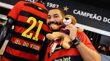Gil do Vigor tem 31 anos e participou da edição de 2021 do Big Brother Brasil Gil do Vigor Homem com um ursinho de pelúcia e camiseta de time vermelha e preta com a escrita 'Gil do Vigor' - Divulgaçao