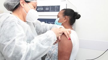 Imunizante estará disponível nas policlínicas de segunda a sexta-feira, das 8h às 16h Santos: vacinação contra a gripe tem início na segunda-feira (10) Pessoa recebe vacina no braço aplicada por enfermeira - Isabela Carrari/Prefeitura de Santos