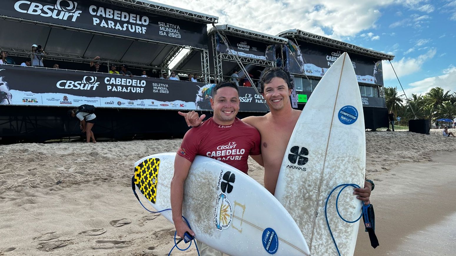 Dois homens seguram prancha de surf  